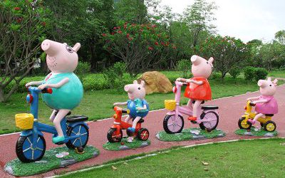 學校公園草坪擺放騎自行車的卡通小豬佩奇一家玻璃鋼雕塑